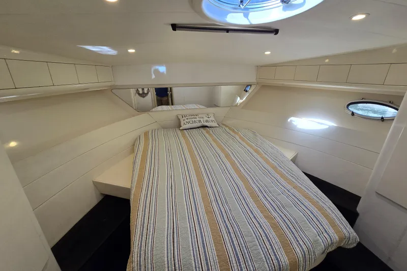 Slide: The Image of Cozy cabin interior of 1993 Giorgi 46 yacht with striped bedding and porthole windows. - 119