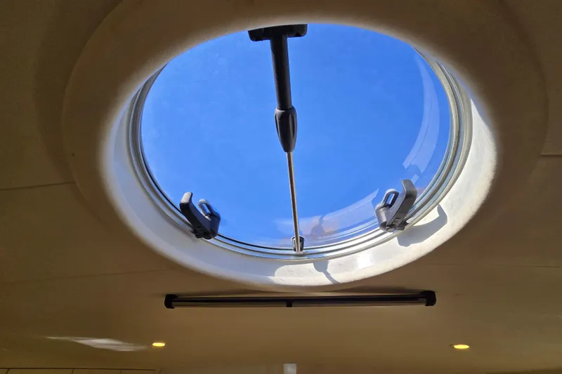 Slide: The Image of Round hatch window on Giorgi 46 yacht, 1993 model, with clear blue sky view. - 125