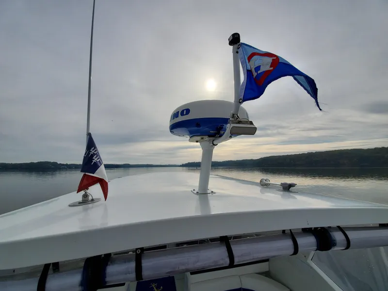Slide: The Image of Boat deck view with flags, radar, and serene water under a cloudy sky. Giorgi 46, 1993 model. - 15
