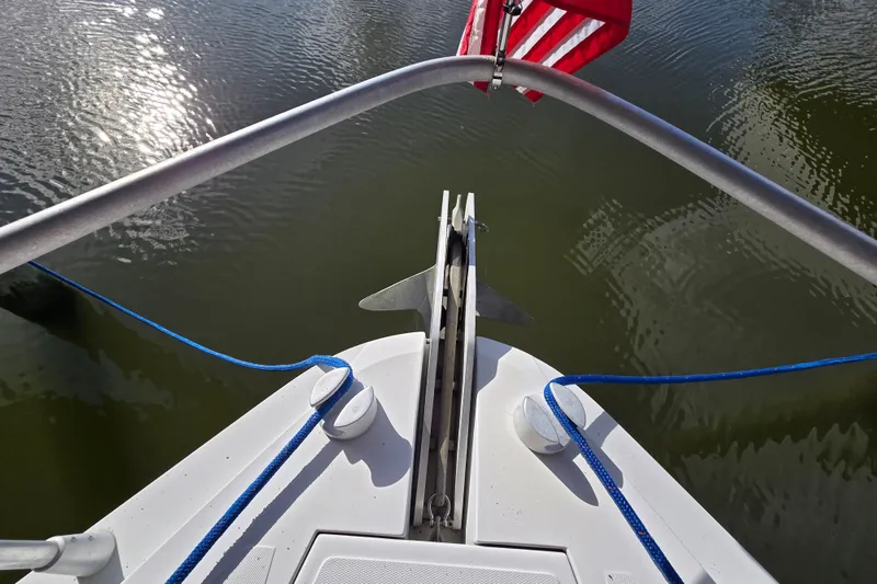 Slide: The Image of Bow of 1993 Giorgi 46 boat with anchor and American flag on calm water. - 94