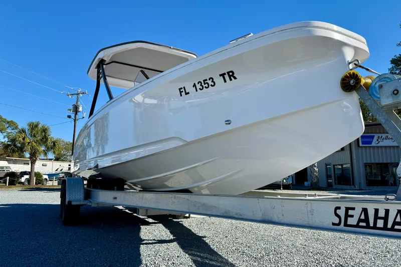Slide: The Image of 2022 Axopar 22 boat on trailer, displayed outdoors under clear blue sky. - 12