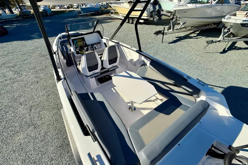 Slide: The Image of 2022 Axopar 22 boat interior with seating and steering console, displayed outdoors. - 18