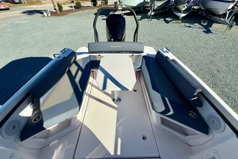 Slide: The Image of 2022 Axopar 22 boat interior with seating and table, parked on gravel. - 19