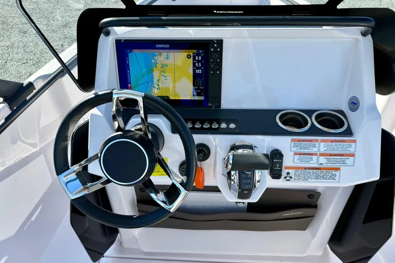 Slide: The Image of 2022 Axopar 22 boat dashboard with steering wheel, navigation display, and controls. - 22