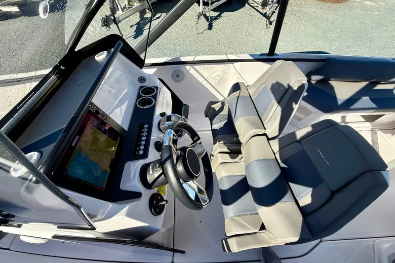 Slide: The Image of 2022 Axopar 22 boat cockpit with steering wheel, navigation system, and comfortable seating. - 25