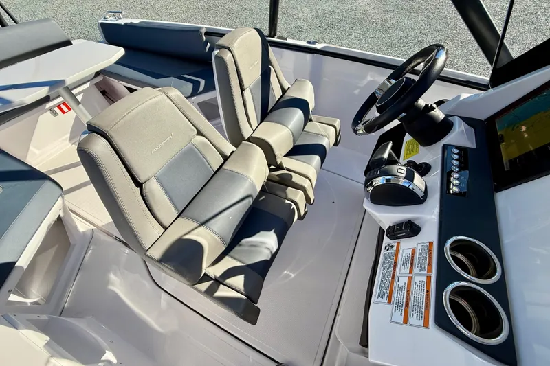 Slide: The Image of Interior of 2022 Axopar 22 boat featuring helm, steering wheel, and seating. - 26