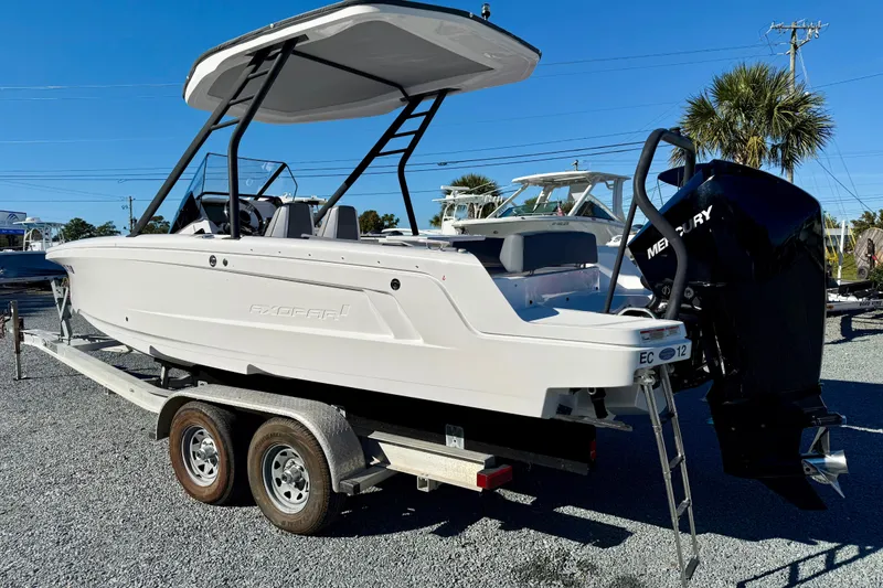 Slide: The Image of 2022 Axopar 22 boat on trailer with Mercury outboard motor, parked outdoors. - 3
