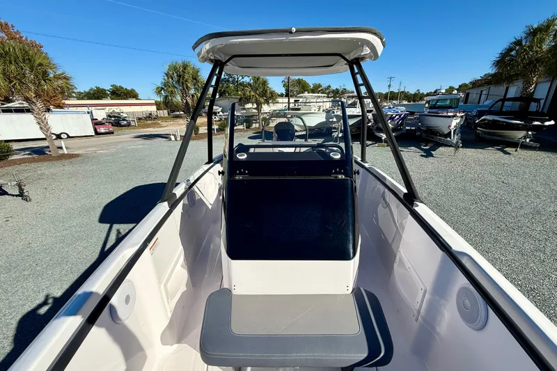 Slide: The Image of 2022 Axopar 22 boat interior with seating and console, displayed outdoors. - 30