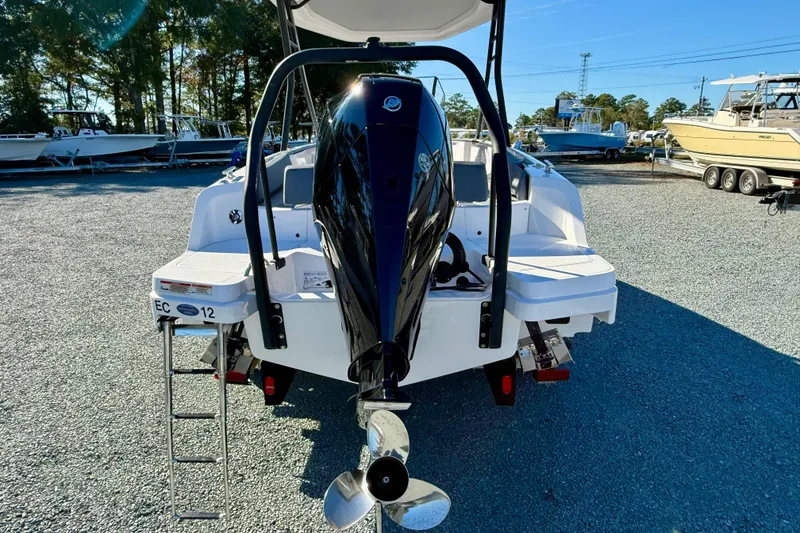 Slide: The Image of 2022 Axopar 22 boat with outboard motor, parked on gravel lot under clear sky. - 5
