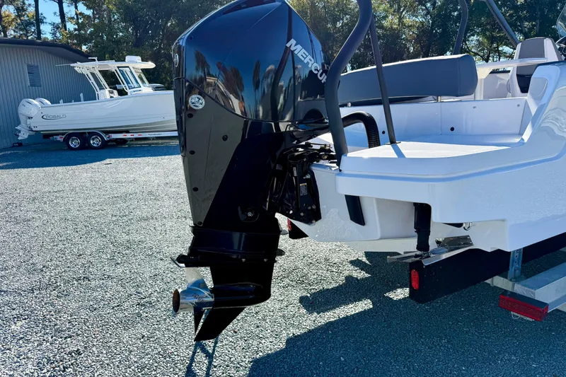 Slide: The Image of 2022 Axopar 22 boat with Mercury outboard engine, parked on gravel. - 6