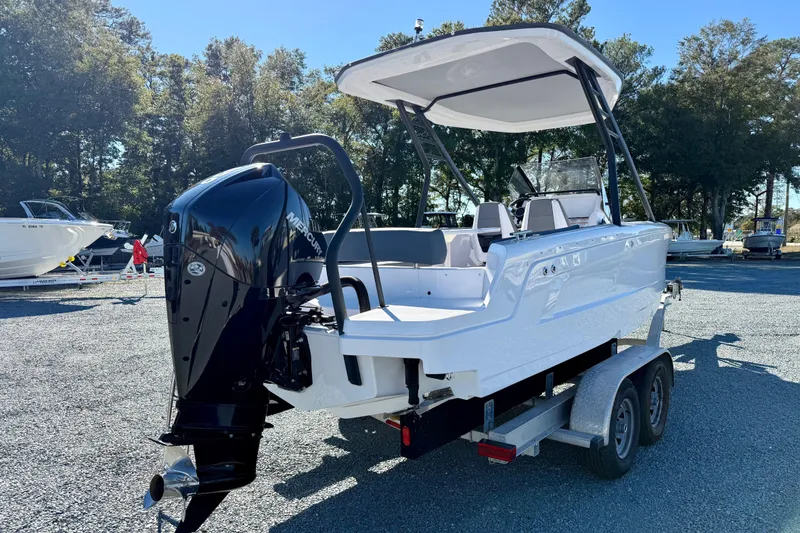 Slide: The Image of 2022 Axopar 22 boat on trailer with Mercury outboard motor, parked outdoors. - 7