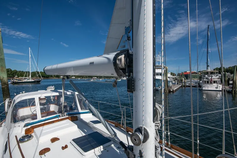 Slide: The Image of Sailboat docked in marina, Hank Hinckley OC42, 1984 model, under clear blue sky. - 16
