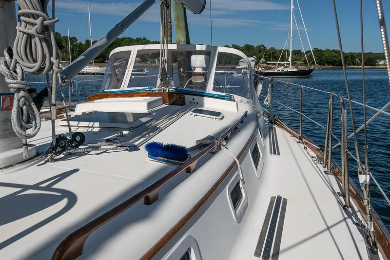 Slide: The Image of 1984 Hank Hinckley OC42 sailboat deck with ropes and equipment, docked in a serene marina. - 19