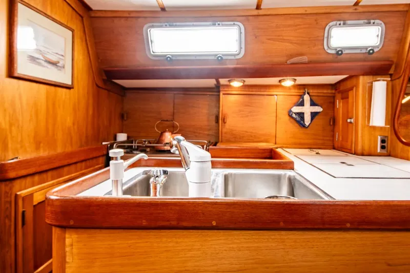 Slide: The Image of Wooden interior of 1984 Hank Hinckley OC42 yacht kitchen with sink and portholes. - 27
