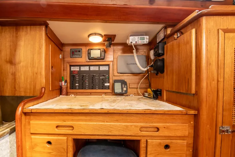 Slide: The Image of Navigation station of 1984 Hank Hinckley OC42 sailboat with wooden cabinetry and electronic equipment. - 31
