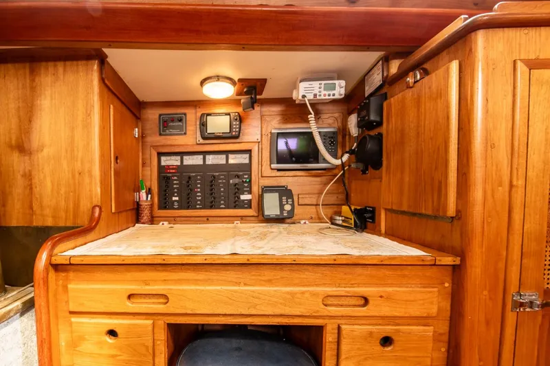 Slide: The Image of Navigation station in 1984 Hank Hinckley OC42 sailboat with wooden cabinetry and communication equipment. - 32