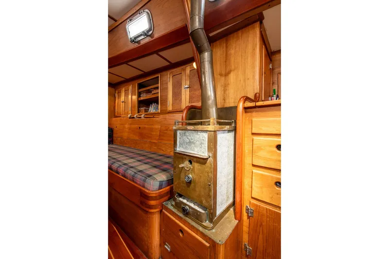 Slide: The Image of Cozy cabin interior of 1984 Hank Hinckley OC42 sailboat with wood stove and plaid seating. - 34