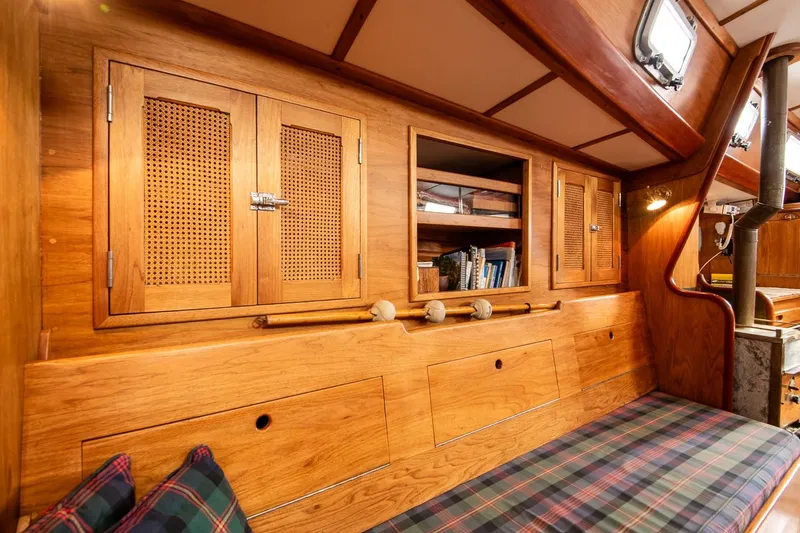 Slide: The Image of Cozy interior of 1984 Hank Hinckley OC42 sailboat with wooden cabinets and plaid seating. - 38