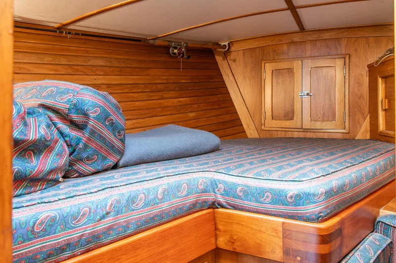 Slide: The Image of Cozy cabin interior of 1984 Hank Hinckley OC42 sailboat with patterned bedding and wooden walls. - 39