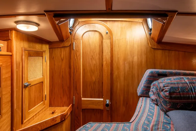 Slide: The Image of Wood-paneled cabin interior of 1984 Hank Hinckley OC42 sailboat with patterned cushions. - 44