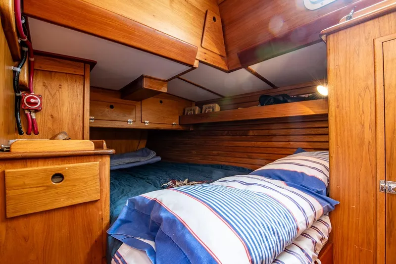 Slide: The Image of Cozy cabin interior of 1984 Hank Hinckley OC42 sailboat with wooden furnishings and striped bedding. - 46
