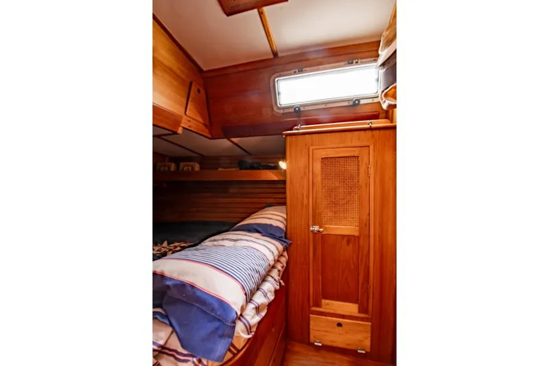Slide: The Image of 1984 Hank Hinckley OC42 yacht cabin with wooden interior and striped bedding. - 47