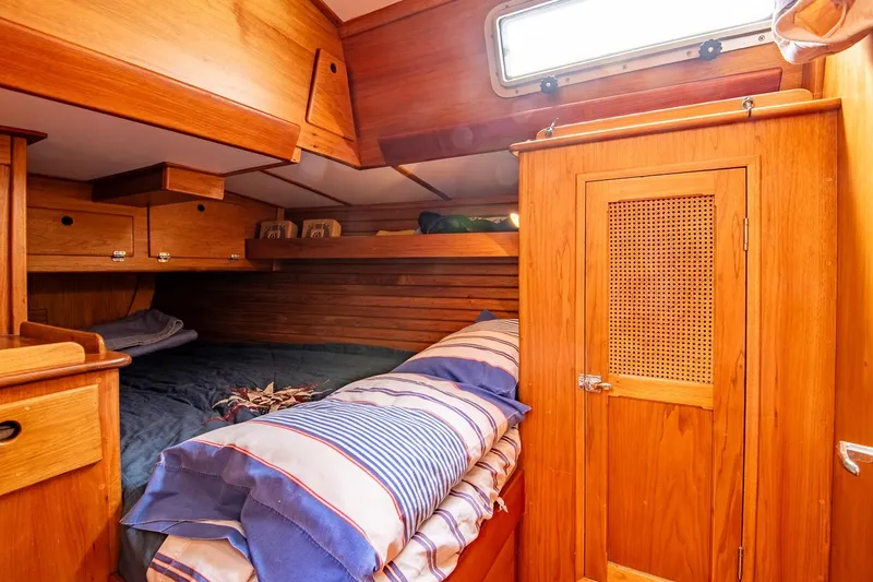 Slide: The Image of Cozy wooden cabin interior of 1984 Hank Hinckley OC42 sailboat with bed and storage. - 48