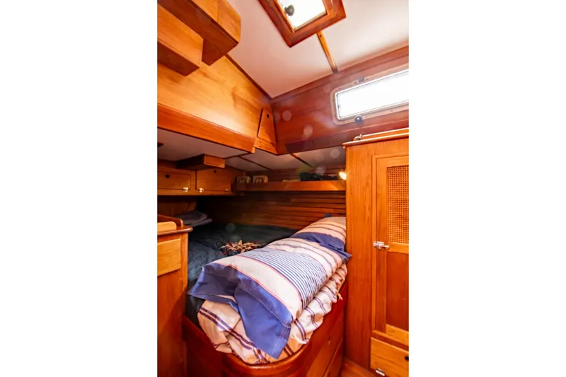 Slide: The Image of Cozy wooden cabin interior of 1984 Hank Hinckley OC42 sailboat with striped bedding. - 49