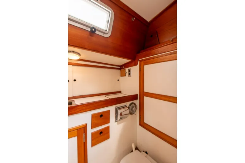 Slide: The Image of 1984 Hank Hinckley OC42 yacht bathroom with wooden cabinetry and porthole window. - 52