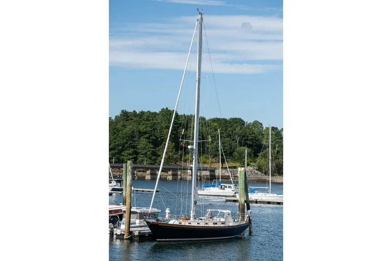 Slide: The Image of Sailboat docked in marina, Hank Hinckley OC42, 1984 model, under clear blue sky. - 9