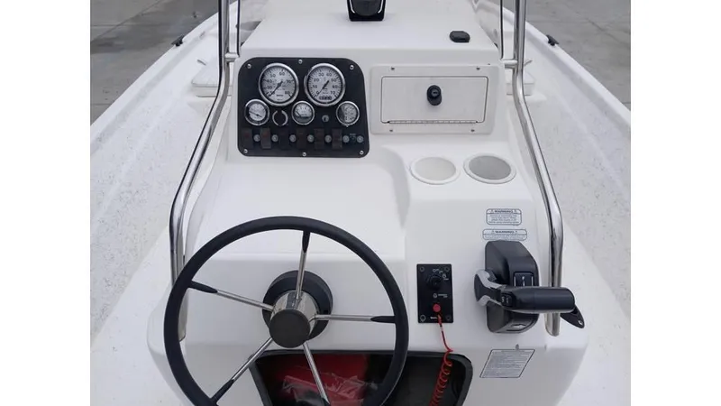 Slide: The Image of Steering console of a 2006 Mako 211 boat with gauges and controls. - 2