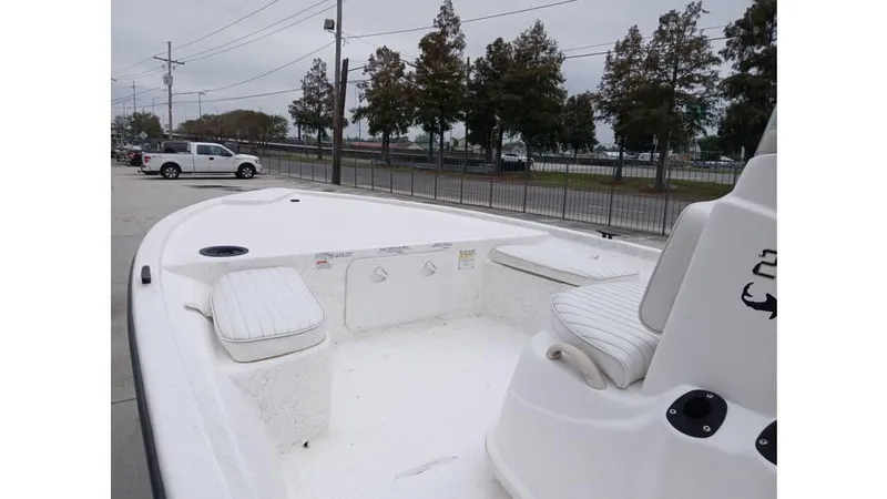 Slide: The Image of 2006 Mako 211 boat interior with white seating, parked outdoors. - 5