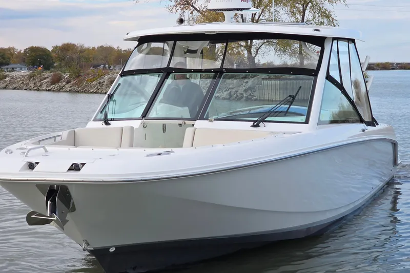 Slide: The Image of 2018 Boston Whaler 320 Vantage boat on calm water, showcasing sleek design and spacious deck. - 10