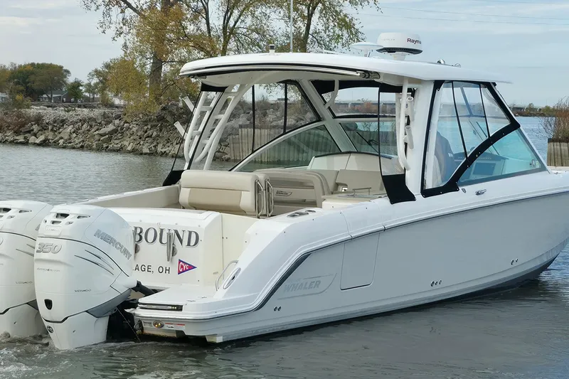 Slide: The Image of 2018 Boston Whaler 320 Vantage boat with twin Mercury 350 engines on a calm lake. - 3