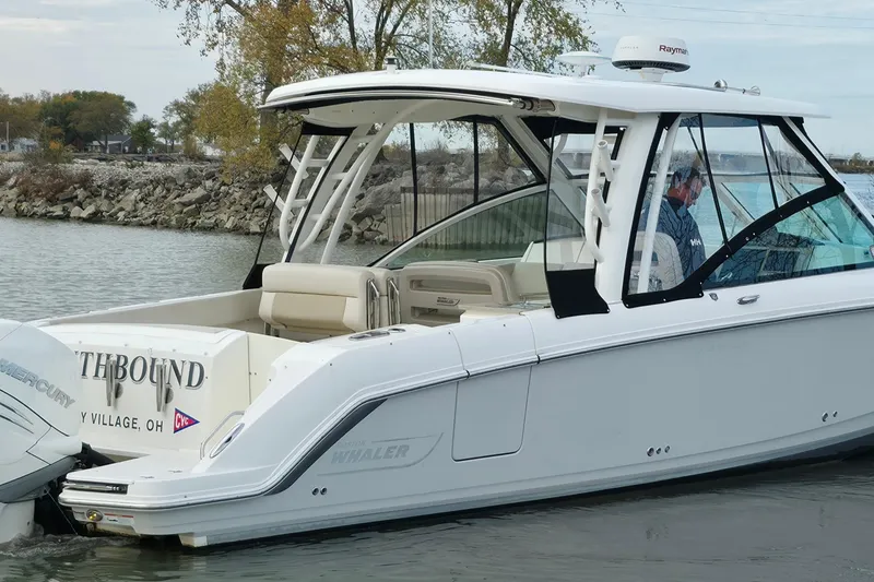 Slide: The Image of 2018 Boston Whaler 320 Vantage boat docked near rocky shoreline. - 4