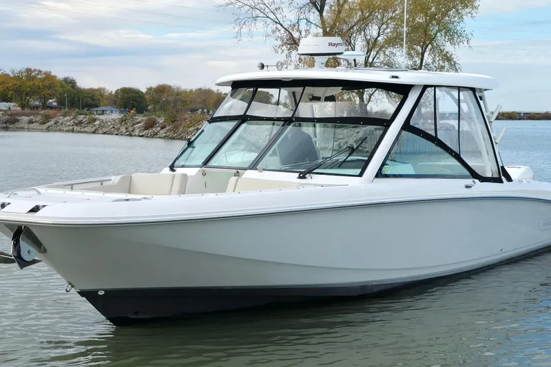 Slide: The Image of 2018 Boston Whaler 320 Vantage boat on calm water, showcasing sleek design and spacious deck. - 8