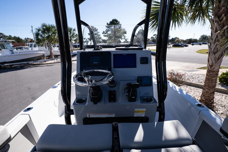 Slide: The Image of 2026 Sea Pro 230 Bay boat with rod holders and T-top, parked outdoors. - 13