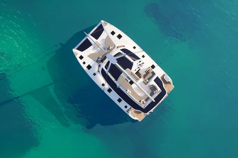 Slide: The Image of Aerial view of 2026 Fountaine Pajot 48 catamaran on clear turquoise water. - 32