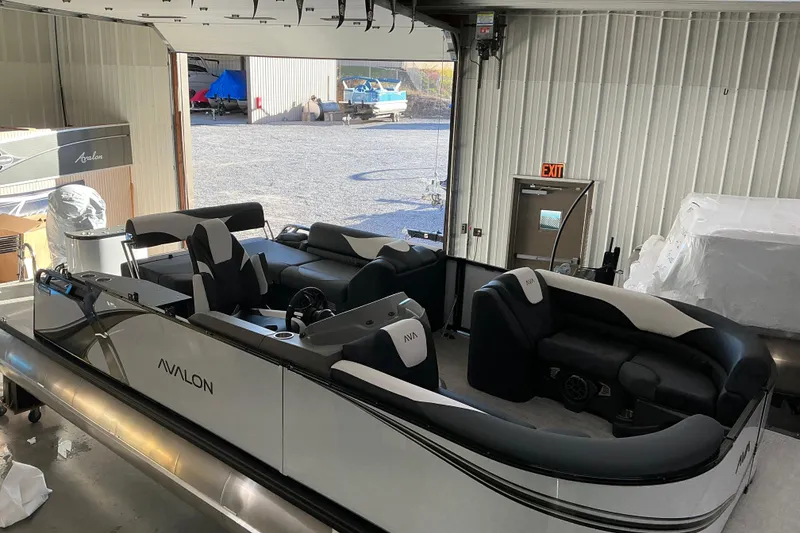 Slide: The Image of 2026 Avalon LSZ CRB pontoon boat in a garage, showcasing sleek design and spacious seating. - 3