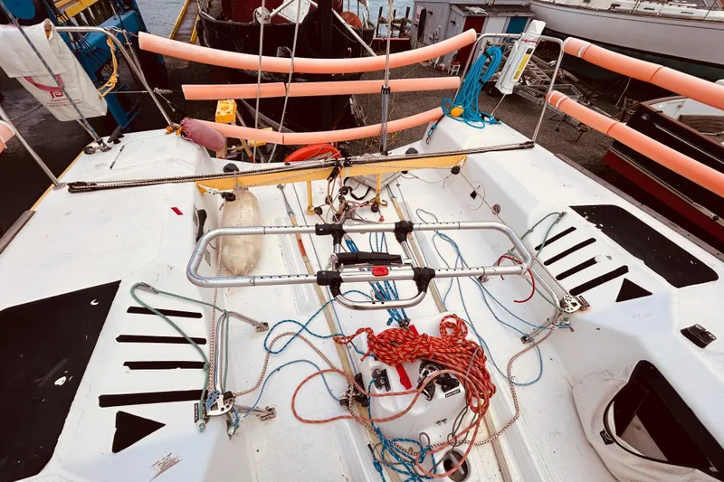 Slide: The Image of 2003 Beneteau Figaro 2 sailboat deck with ropes and equipment, docked at marina. - 14