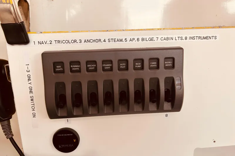 Slide: The Image of Control panel of a 2003 Beneteau Figaro Beneteau 2 sailboat with labeled switches. - 19