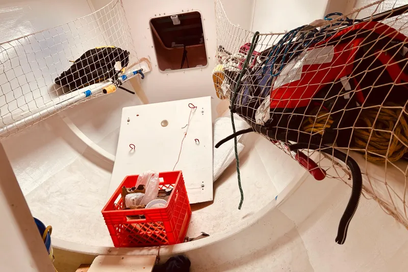 Slide: The Image of Interior of 2003 Beneteau Figaro 2 sailboat with storage nets and equipment. - 21