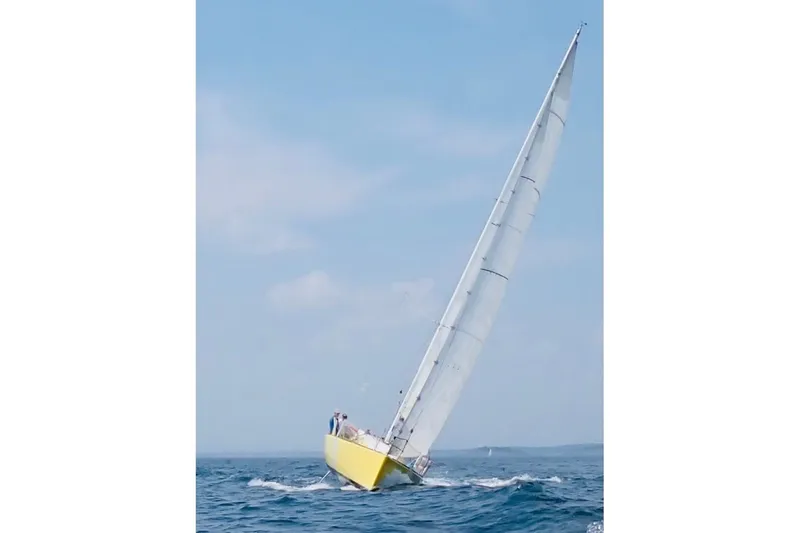 Slide: The Image of Yellow 2003 Beneteau Figaro Beneteau 2 sailboat navigating ocean waters. - 27