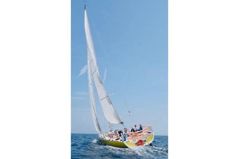 Slide: The Image of 2003 Beneteau Figaro Beneteau 2 sailing on open sea under clear blue sky. - 25
