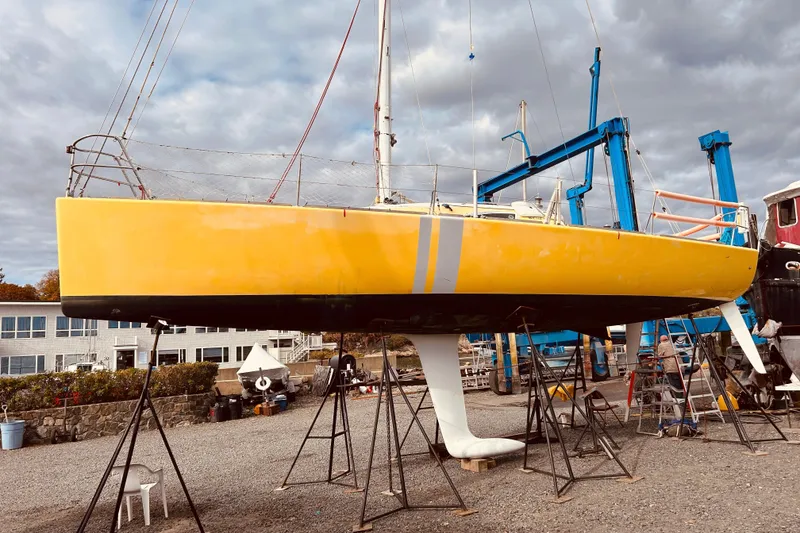 Slide: The Image of Yellow 2003 Beneteau Figaro Beneteau 2 sailboat on stands in a boatyard. - 3