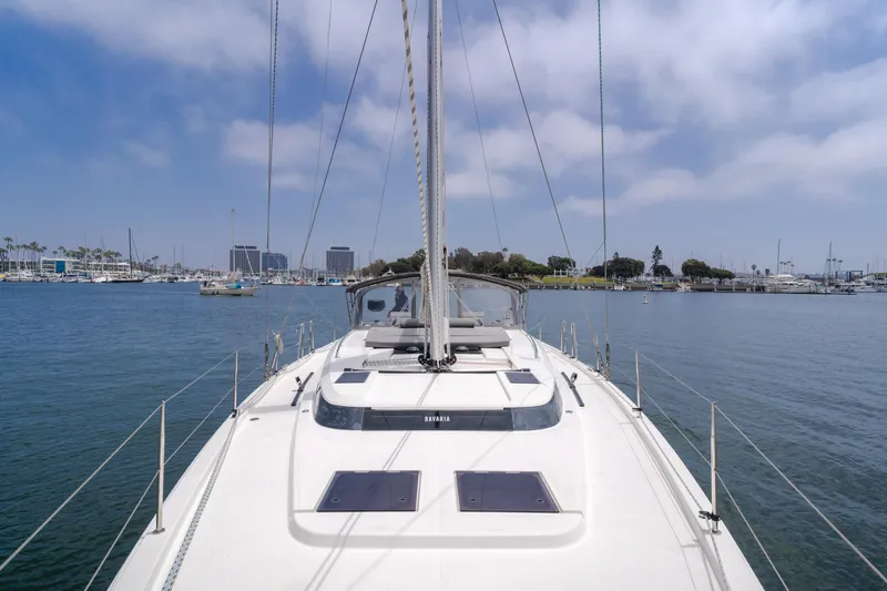 Slide: The Image of 2021 Bavaria C50 Style yacht sailing in a calm marina under a partly cloudy sky. - 26