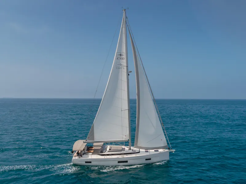 Slide: The Image of 2021 Bavaria C50 Style sailboat cruising on open sea under clear blue sky. - 3