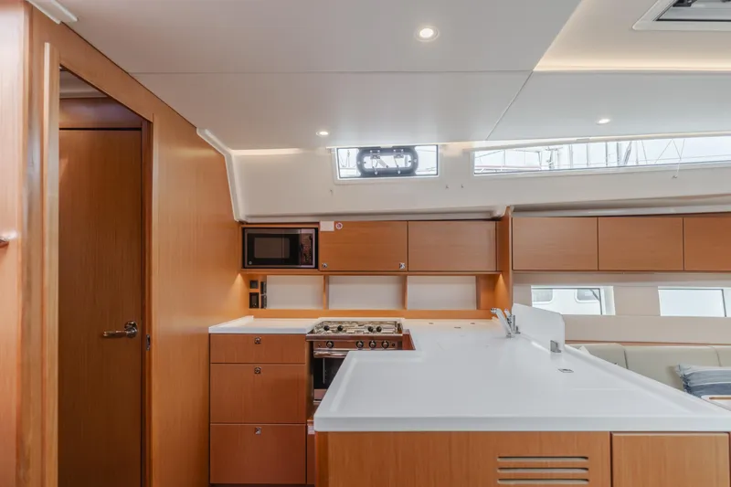 Slide: The Image of Modern kitchen interior of 2021 Bavaria C50 Style yacht with wood cabinetry and white countertops. - 36