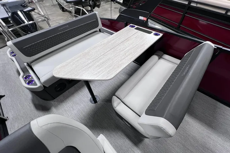 Slide: The Image of 2026 Harris Sunliner 250 SLE boat interior with seating and table, featuring modern design and cup holders. - 19