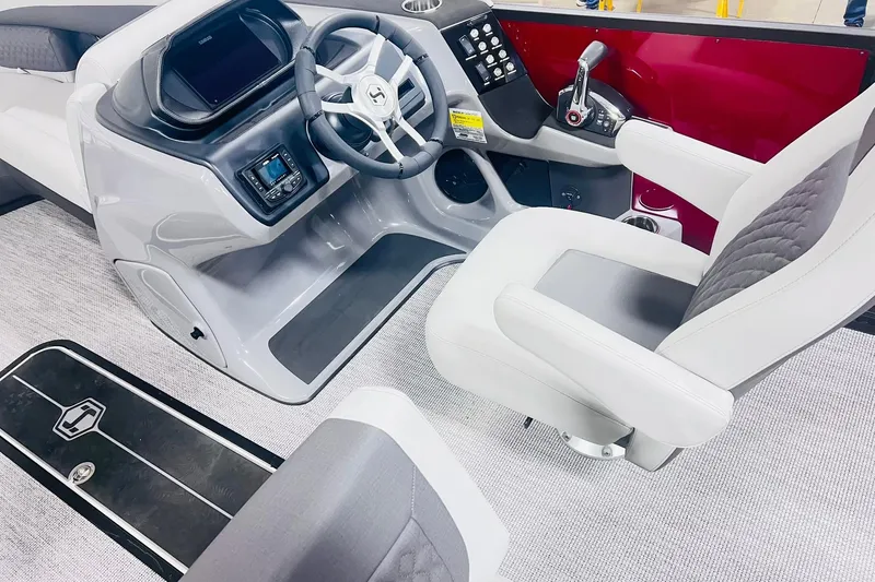 Slide: The Image of Interior of 2026 Harris Sunliner 250 SLE boat, featuring modern helm and seating. - 27